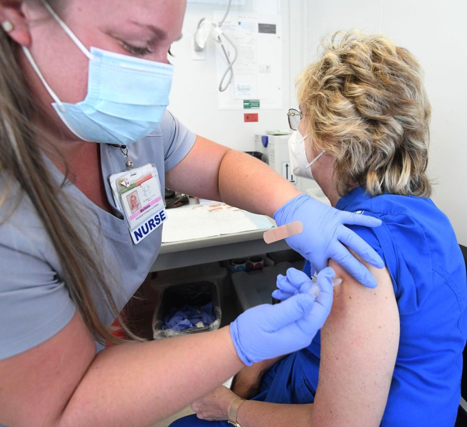 Melissa Moreau, R.N., gives a third COVID-19 booster shot to Ann Hartman, R.N., Friday at the Hartford HealthCare vaccine clinic on Stott Avenue in Norwich.