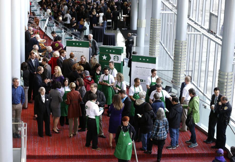 Shareholders and other guests arrive for the annual Starbucks Coffee Company shareholders meeting, Wednesday, March 19, 2014, in Seattle. (AP Photo/Ted S. Warren)