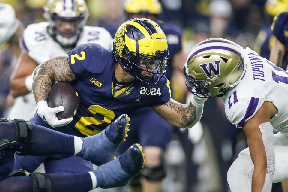 Michigan running back Blake Corum runs against Washington linebacker Alphonzo Tuputala during the first half of the national championship game at NRG Stadium in Houston, Texas on Monday, Jan. 8, 2024.