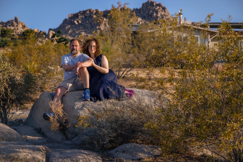 Colin Campbell and his wife Gail sitting on a rock in Joshua Tree.