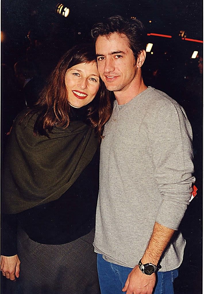 Catherine Keener hugs Dermot Mulroney from behind