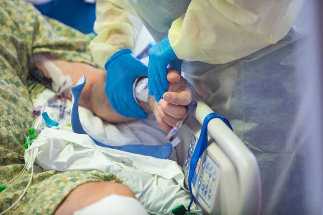 In this file photo from August 2021, a nurse holds the hand of a COVID-19 patient in the Medical Intensive care unit at St. Luke's Boise Medical Center in Boise, Idaho.  (Photo: AP Photo/Kyle Gree,File)