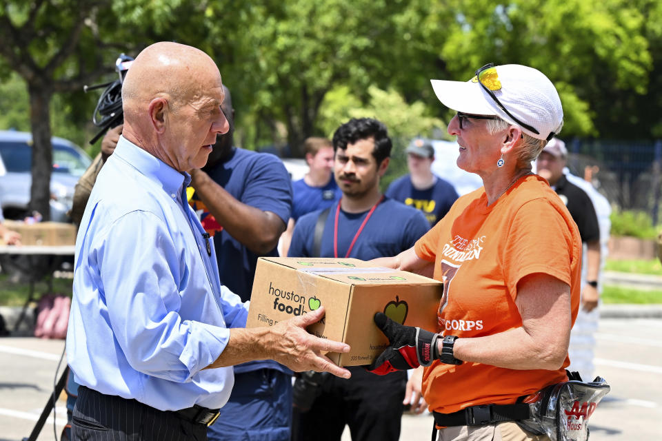 Houston Mayor John Whitmire, left, and Karen Jones help handing out food boxes at Acres Homes cooling center in Houston, Wednesday, July 10, 2024. Hurricane Beryl slammed into Texas, knocking out power to nearly 3 million homes and businesses. (AP Photo/Maria Lysaker)