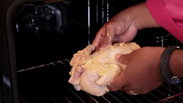 place marinated whole chicken into oven middle rack