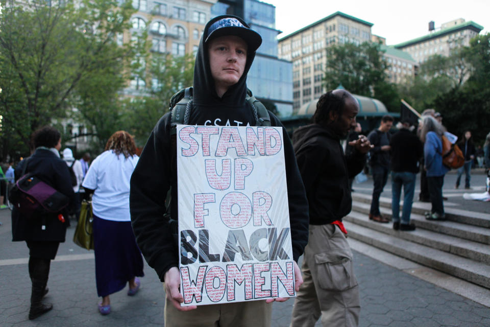 Adam Stadacher, activist, holding a sign that reads "Stand up for black women."