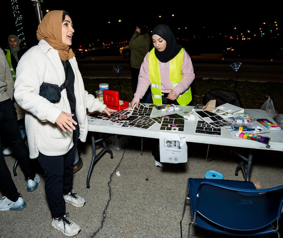 Sahar Ahmad, left, Salam School teacher and one of the event organizers, speaks with sophomore Qanat Abdeljawad as they prepare activities for families attending the Suhoor Food Truck Festival.