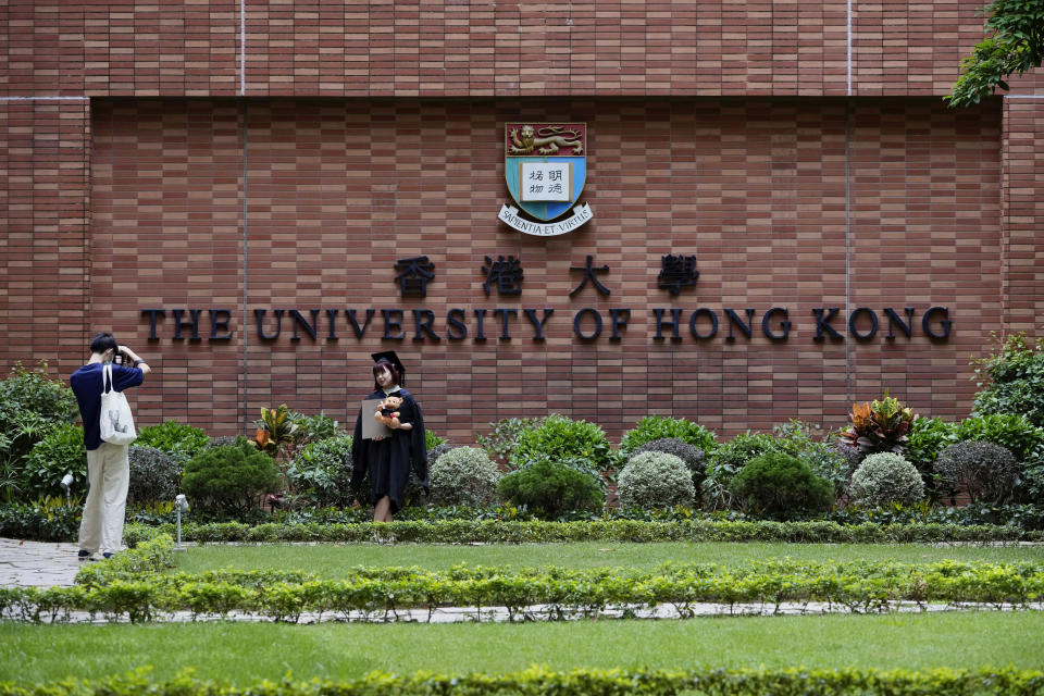 Students take a photo in the campus of the University of Hong Kong, Friday, July 16, 2021. Hong Kong's national security police on Friday raided the office of a student union at the local university, after student leaders last week commemorated the death of an attacker who killed himself after stabbing a police officer. (AP Photo/Kin Cheung)