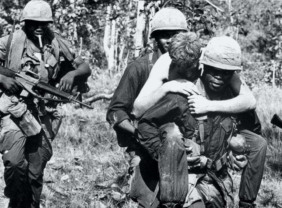 A wounded soldier is carried by members of the 1st Calvary Division near the Cambodian border during the Vietnam War. <a href="https://www.gettyimages.com/detail/news-photo/wounded-soldier-is-carried-by-members-of-the-1st-calvary-news-photo/514870008?phrase=vietnam%20war%20black%20soldiers&adppopup=true" rel="nofollow noopener" target="_blank" data-ylk="slk:Bettmann/GettyImages;elm:context_link;itc:0;sec:content-canvas" class="link ">Bettmann/GettyImages</a>
