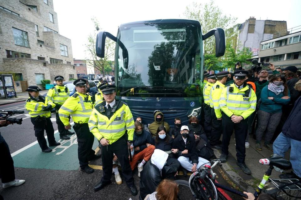 Police confronting protesters who are forming a blockade around the coach (Yui Mok/PA Wire)