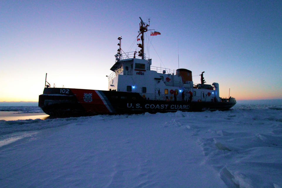 The crew of the Coast Guard Cutter Bristol Bay witnesses the morning sunrise while sitting in a frozen section of Lake Huron, Feb. 10, 2015.