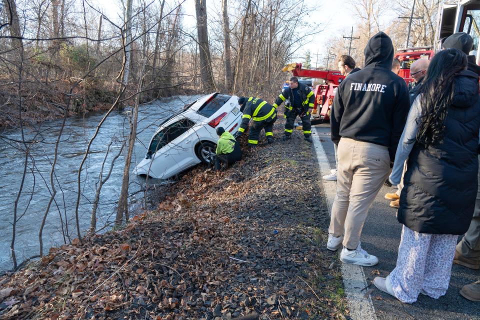 A car slid on the ice and careened down the embankment into the Passaic River in Totowa, NJ on Tuesday Dec. 12, 2023. The vehicle was occupied by a mother and her teenage son, traveling on Riverview Dr when the car slid on the ice, which then crossed the roadway, hitting trees before coming to a stop in the Passaic River. The mother and her son escaped from the vehicle by exiting from the sunroof. According to Totowa Fire Chief Rich Schopperth, the mother and son were evaluated and released by EMS at the scene.