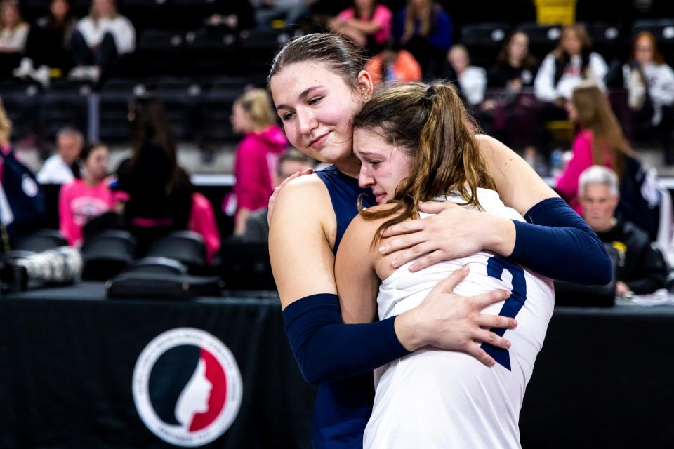Des Moines Christian's Gabby Bartek hugs teammate Finley Schelhaas (2) after their loss to Davenport Assumption during the IGHSAU state volleyball tournament Tuesday