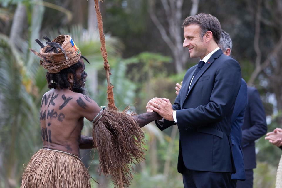 French President Emmanuel Macron shakes hands with a traditional dancer during a customary ceremony in his honour in Touho, north of New Caledonia (POOL/AFP/Getty)