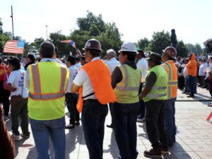  Men wearing construction vests and hard hats stand at a protest outside the Oklahoma State Capitol during Hispanic Cultural Day on Wednesday. (Photo by Nuria Martinez-Keel/Oklahoma Voice)