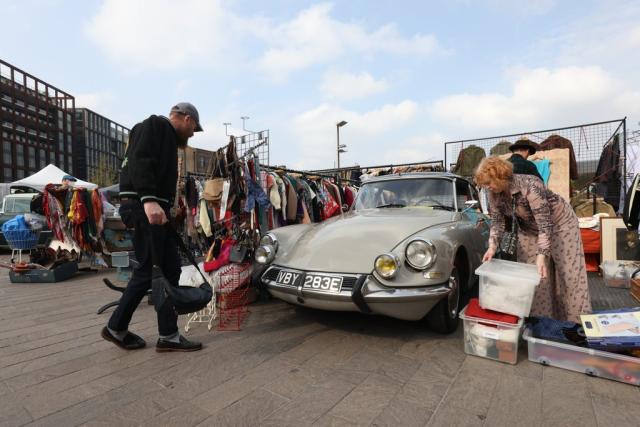 A stallholder arranges boxes next to her 1967 Citroen DBS (James Manning/PA) (PA Wire)
