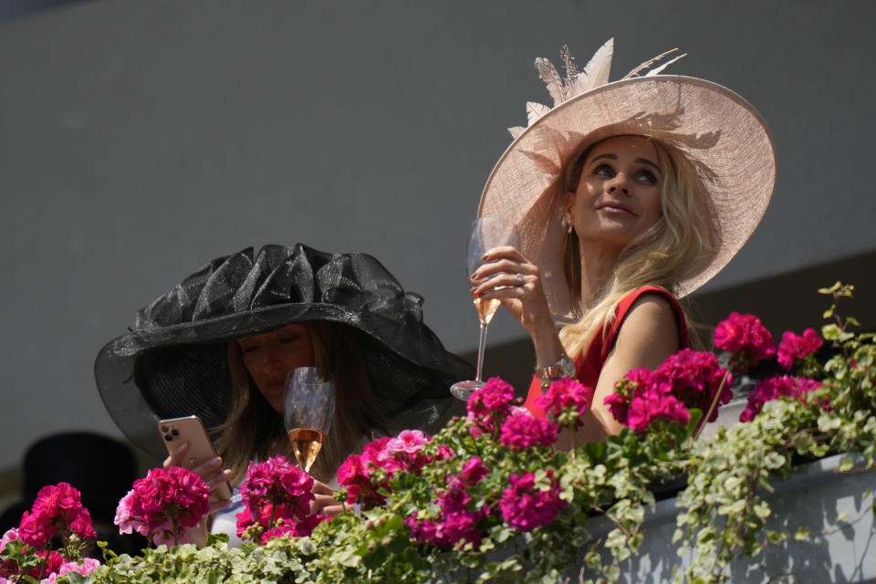 Racegoers wear ornate hats as they look down on the parade ring on the second day of of the Royal Ascot horserace meeting, at Ascot Racecourse, in Ascot, England, Wednesday, June 15, 2022. (AP Photo/Alastair Grant)