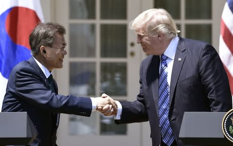 Donald Trump shaking hands with South Korean President Moon Jae-in during a joint press conference in the Rose Garden at the White House in Washington, DC in June. - Credit: AFP