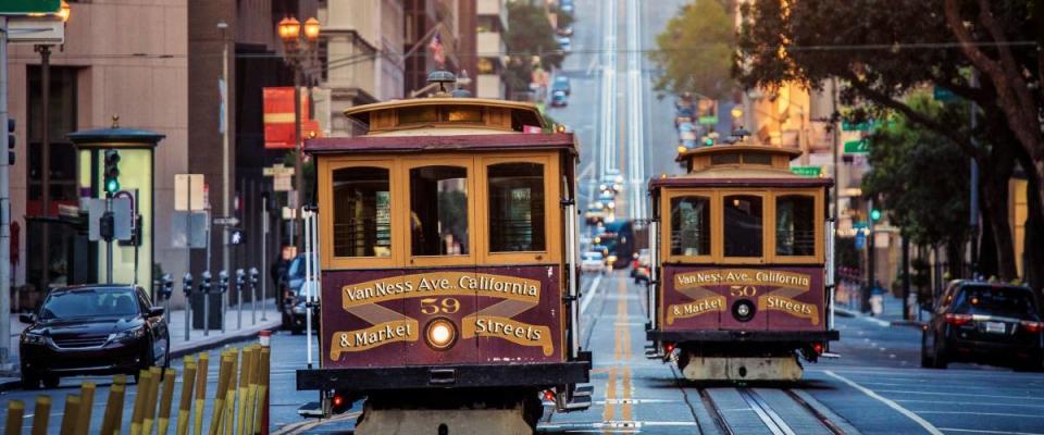 Classic view of historic traditional Cable Cars riding on famous California Street in San Francisco