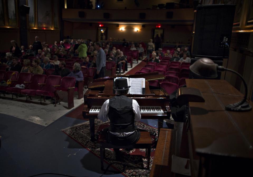 Pianist Jim Dickson entertains the audience prior to an evening show. He plays his instrument before or during intermissions in movies or live entertainment. (Reuters)