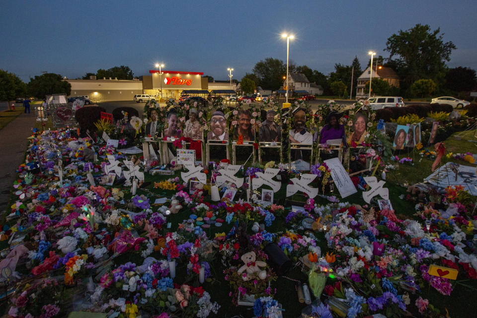 A memorial to the victims of the racially motivated mass shooting at a Tops supermarket in Buffalo, N.Y.,  remains on a lawn near the store.