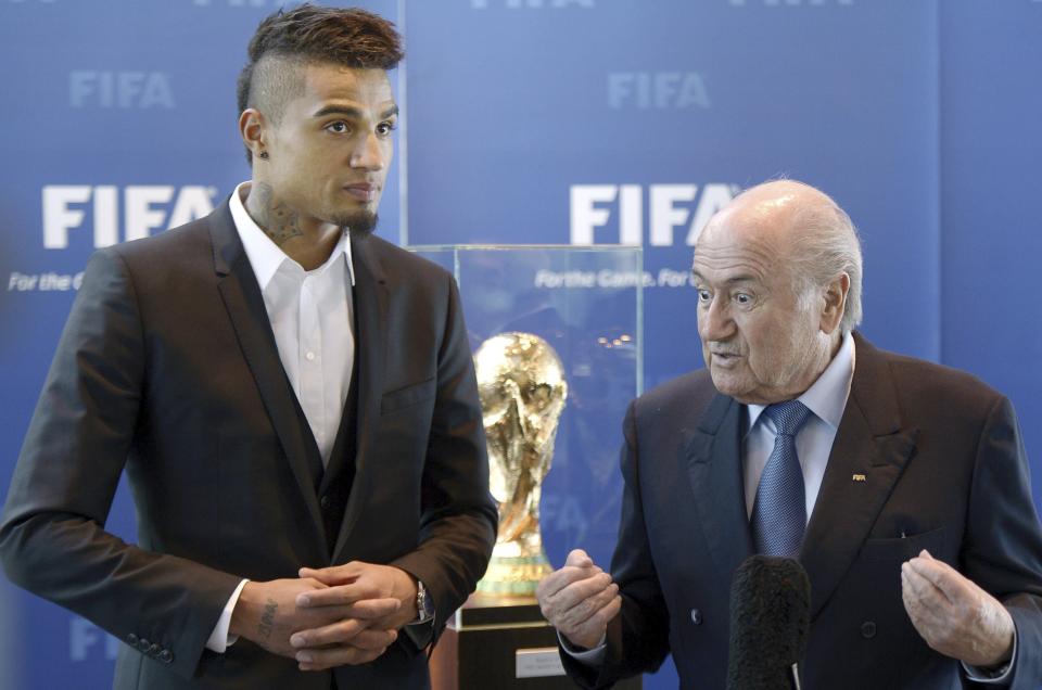 FILE - AC Milan's midfielder and Ghana international soccer player Kevin-Prince Boateng, left, meets FIFA President Sepp Blatter, right, at the FIFA headquarters in Zurich, Switzerland, Friday, March 22, 2013. (AP Photo/Keystone, Walter Bieri, File)