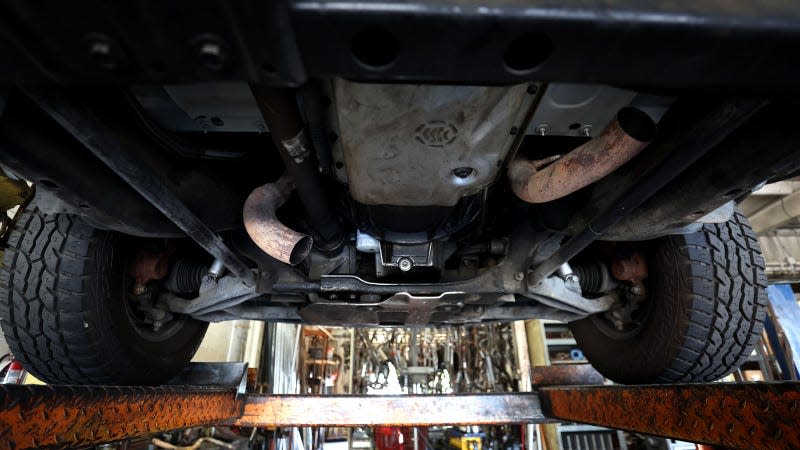 A photo of the underside on a car in a workshop. 