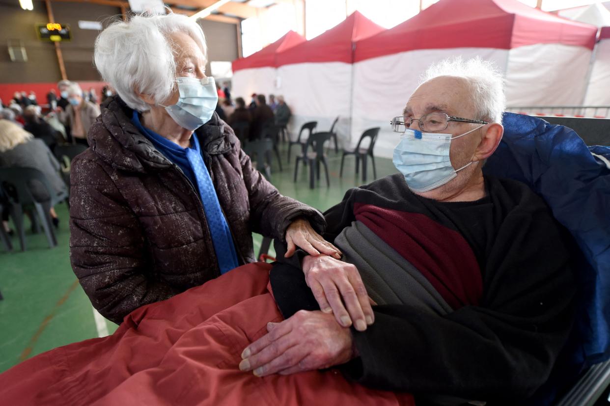 Francis, 90, lays on a stretcher as his wife Josette, 87, waits after receiving the Pfizer/BioNTech vaccine in a gymnasium in Nogent-le-Rotrou, western France, on April 3, 2021. 770 second doses are expected to be administered during a flash vaccination day.