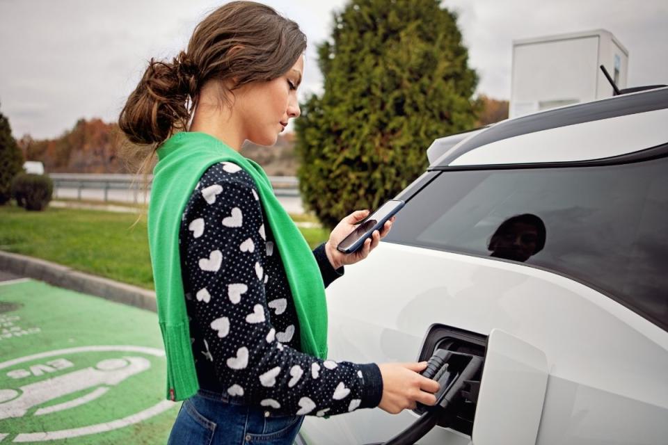 Driver charges electric car at electric vehicle charging station