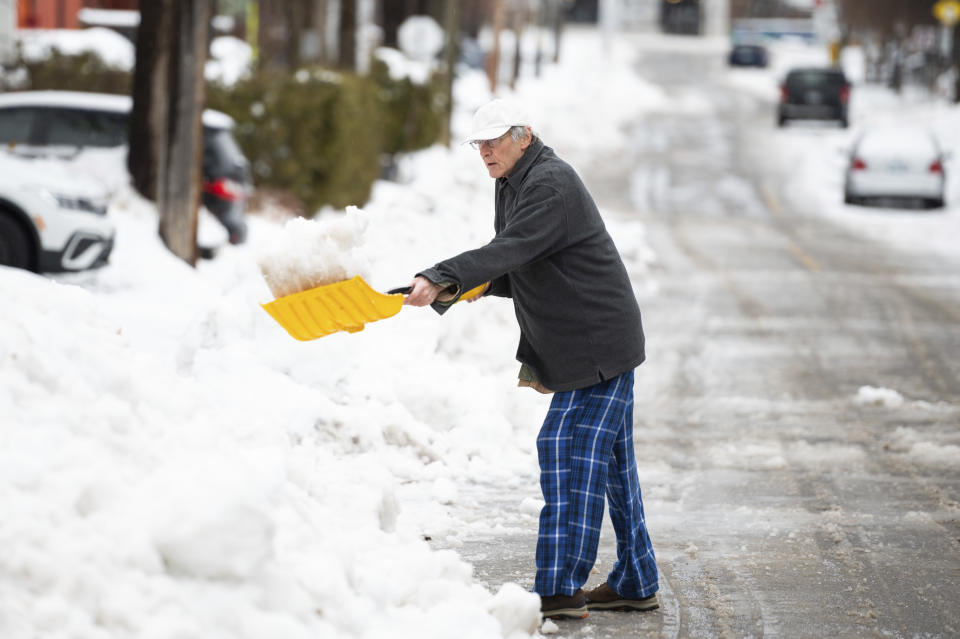 A local resident shovels snow in the Old Ottawa South neighborhood of Ottawa, on Friday, Dec. 23, 2022. Environment Canada has issued a winter storm warning for the region which is calling for flash freezing, icy and slippery surfaces, wind gusts and chills. (Spencer Colby /The Canadian Press via AP)