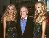 Hugh Hefner celebra el lanzamiento del número de mayo de 2000 de la revista Playboy. En la imagen posa con sus novias y modelos de la portada de ese número: Sandy y Mandy Bentley. (Photo by Arnaldo Magnani)