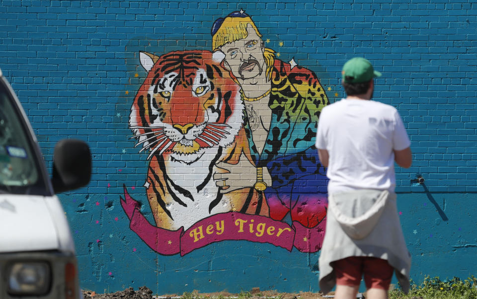 A man looks at a mural depicting Joseph Maldonado-Passage, also known as "Joe Exotic," in Dallas, Friday, April 10, 2020. The Netflix series "Tiger King," has become popular watching during the COVID-19 outbreak. Maldonado-Passage was convicted in an unsuccessful murder-for-hire plot. (AP Photo/LM Otero)