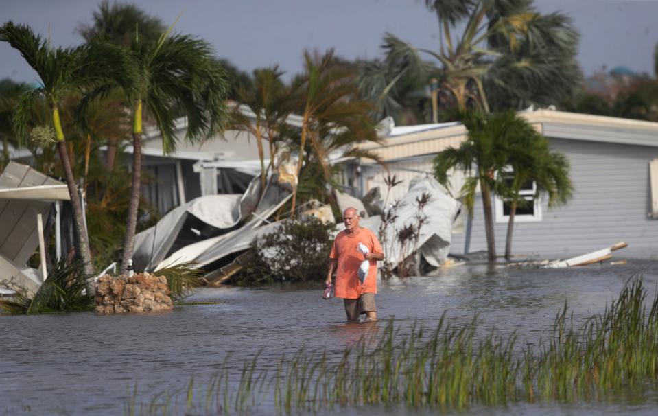 Stan Pentz walks out of a Iona neighborhood  Hurricane Ian made landfall on Wednesday, Sept. 28, 2022.  He survived by swimming in an holding onto items around his home.  