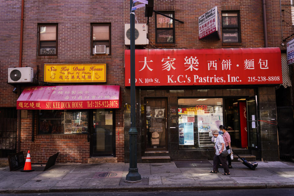 Pedestrians walk along 10th Street in the Chinatown neighborhood of Philadelphia, Friday, July 22, 2022. Organizers and members of Philadelphia's Chinatown say they were surprised by the 76ers' announcement that they hope to build a $1.3 billion arena just a block from the community’s gateway arch. (AP Photo/Matt Rourke)