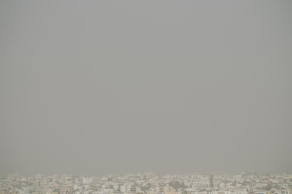 A haze caused by dust covers the capital Nicosia, in the southeast Mediterranean island of Cyprus, on Monday, April 4, 2022. The U.N. health agency says nearly everybody in the world breathes air that doesn't meet its standards for air quality. The World Health Organization is calling for more action reduce fossil-use use that generate pollutants that cause respiratory and blood-flow problems and lead to millions of preventable deaths each year. (AP Photo/Petros Karadjias)