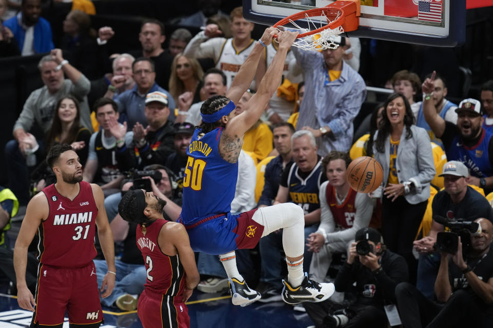 Denver Nuggets forward Aaron Gordon (50) dunks next to Miami Heat guard Gabe Vincent (2) during the first half of Game 1 of basketball's NBA Finals, Thursday, June 1, 2023, in Denver. (AP Photo/David Zalubowski)