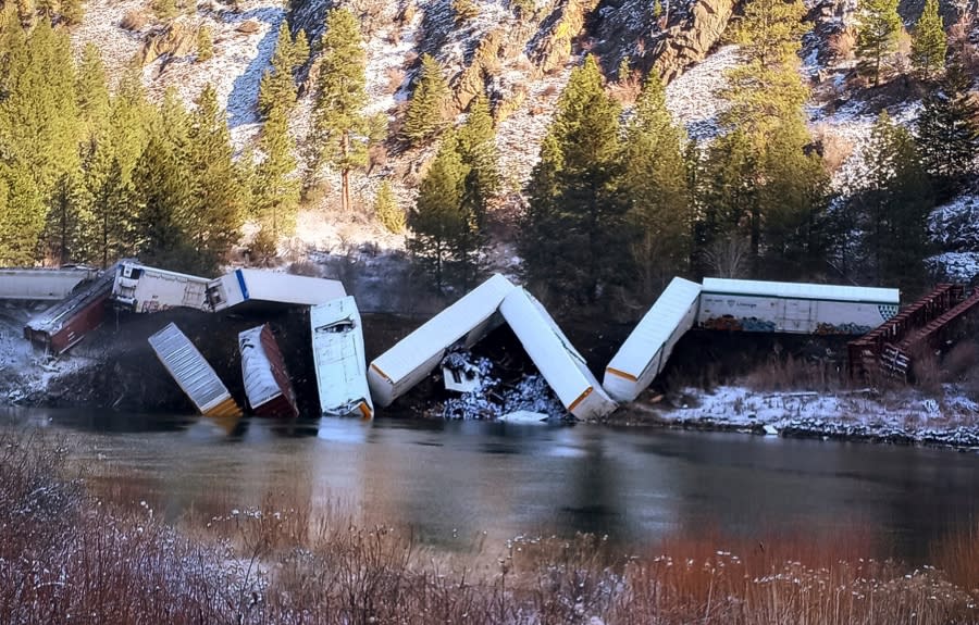 This image provided by Daffney Clairmont shows a train derailed along the Clark Fork River near Paradise, Mont., Sunday, April 2, 2023. Authorities say about 25 train cars derailed. (Daffney Clairmont via AP)