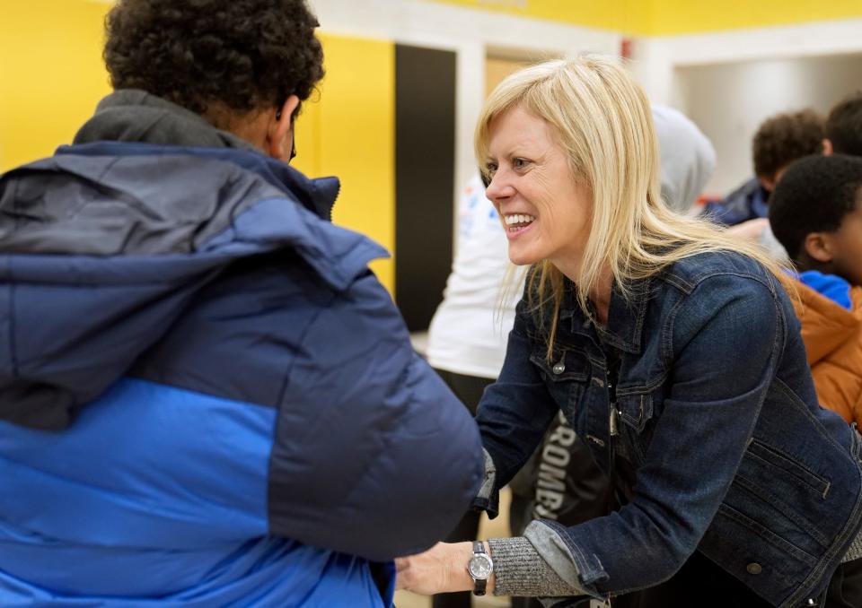 Teresa Morgan, a literacy coach with the Columbus City Schools, helps a child try on winter coats provided in a partnership with the United Way of Central Ohio on Nov. 16during a distribution event at Burroughs Elementary School