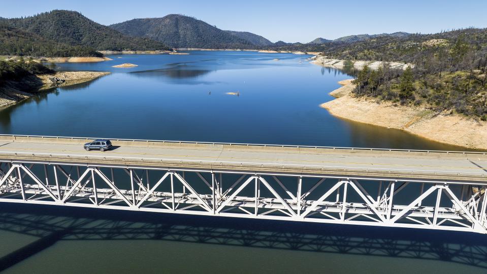 A car crosses Enterprise Bridge over Lake Oroville on Sunday, March 26, 2023, in Butte County, Calif. Months of winter storms have replenished California's key reservoirs after three years of punishing drought. (AP Photo/Noah Berger)