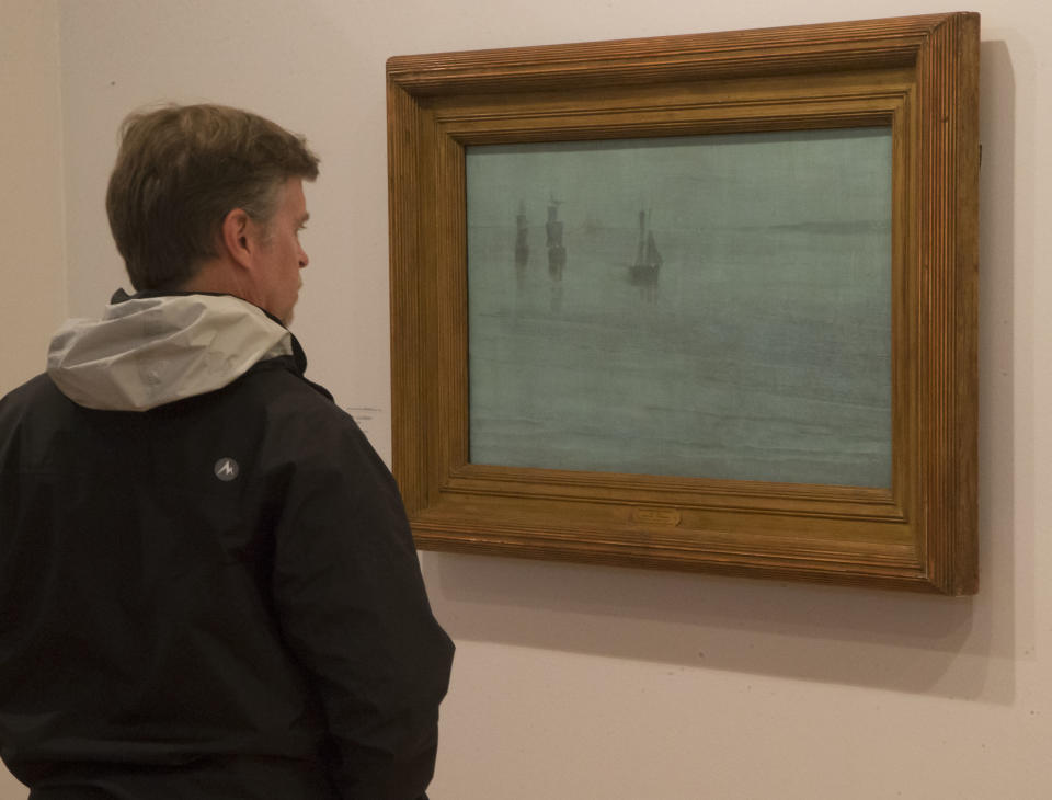 A man looks at a painting by American painter James Abbott McNeill Whistler, 1834-1903, "Nocturne: The Solent", 1866, during the exhibition "American Impressionism: A New Vision", at the Impressionist museum in Giverny, 70 kms (45 mls)north west of Paris, during the Friday, March 28, 2014. A new exhibit at Normandy’s Impressionism Museum tells for the first time the little-known story of American Impressionism from where it all began _ at the picturesque water lily-filled Giverny gardens of Claude Monet that Americans colonized for three decades. (AP Photo/Michel Euler)