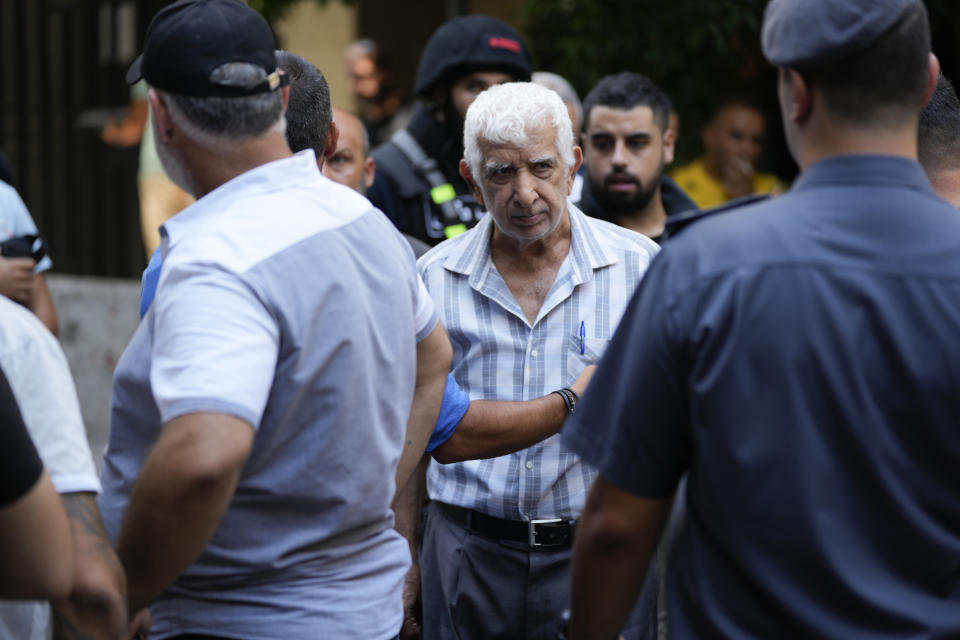 A released hostage walks out of a bank where another armed man holds hostages in Beirut, Lebanon, Thursday, Aug. 11, 2022. A Lebanese security official says a man armed with a shotgun has broken into a Beirut bank, holding employees hostage and threatening to set himself ablaze with gasoline unless he receives his trapped saving. (AP Photo/Hussein Malla)