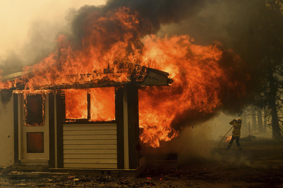 Image: A firefighter battles the Morton Fire as it consumes a home near Bundanoon, New South Wales, Australia, (Noah Berger / AP file)