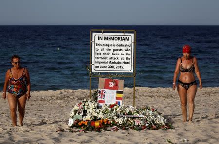 Tourists pass a plaque dedicated to victims on the beach of the Imperial Marhaba resort, on the first anniversary of an attack by a gunman at the hotel in Sousse, Tunisia June 26, 2016. REUTERS/Zohra Bensemra
