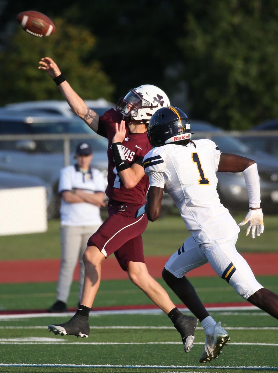 Aquinas quarterback Trent Buttles throws on the run as he scrambles to his right, away from UPrep's Tyrell Simmons.