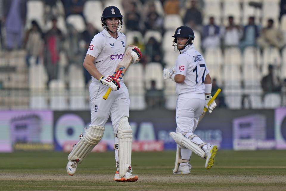England's Harry Brook, left, and Ben Duckett run between the wickets during the second day of the second test cricket match between Pakistan and England, in Multan, Pakistan, Saturday, Dec. 10, 2022. (AP Photo/Anjum Naveed)