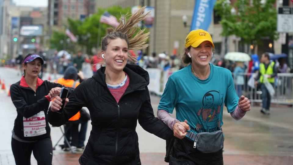 Katie Wagner, 33, rejoices at the finish line with her sister Lindsey Loria, 36, as they complete the 2022 OhioHealth Cap City Half Marathon held Saturday. They said they ran in honor of Loria's late husband, Armando, who died in 2021.