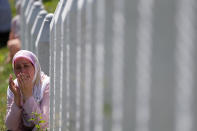 <p>A Bosnian Muslim woman prays among gravestones during a funeral ceremony for dozens of newly identified victims of the 1995 massacre, at the memorial centre of Potocari near Srebrenica, 150 kms north east of Sarajevo, Bosnia, Tuesday, July 11, 2017. (Photo: Amel Emric/AP) </p>