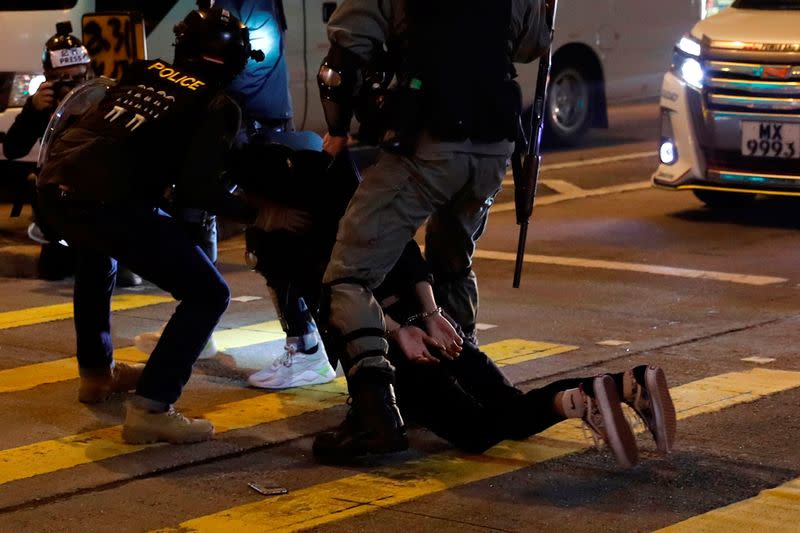 Riot police officers detain an anti-government protester during a demonstration on New Year's Eve outside Mong Kok police station in Hong Kong