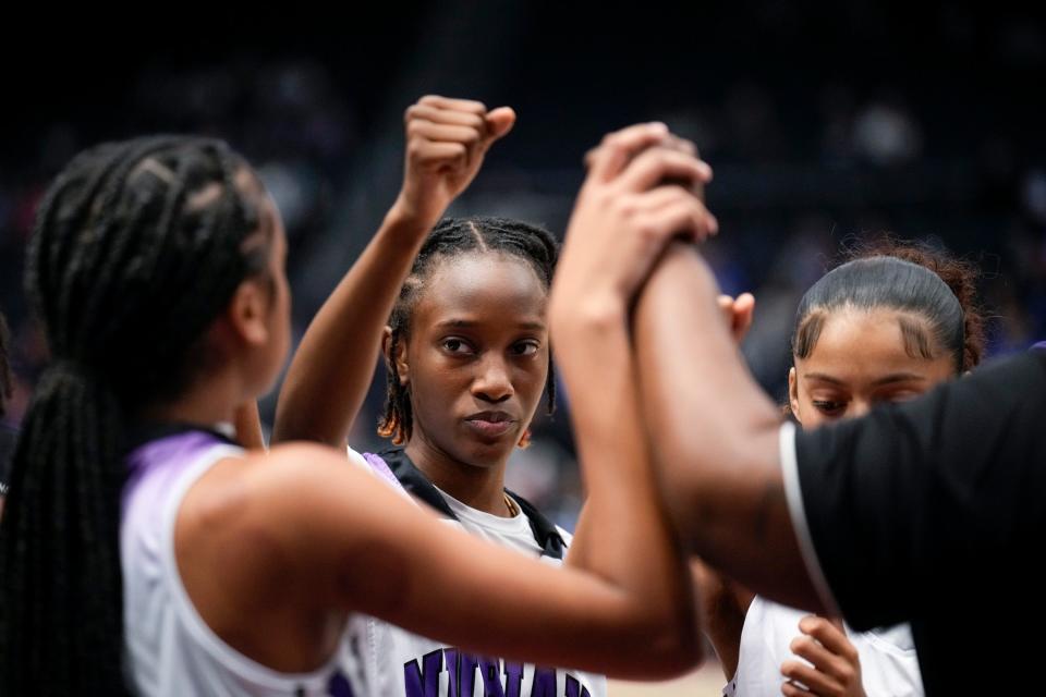 Africentric's Ashtan Winfrey, who scored 14 points Saturday, huddles with her teammates in the fourth quarter.