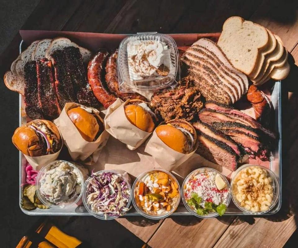 A platter with barbecue, burgers and side dishes at Dayne’s Craft Barbecue in Fort Worth.