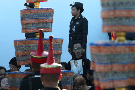 A well-wisher holds up a portrait of late Thailand's King Bhumibol Adulyadej during a his funeral rehearsal for near the Grand Palace in Bangkok, Thailand October 21, 2017. REUTERS/Kerek Wongsa